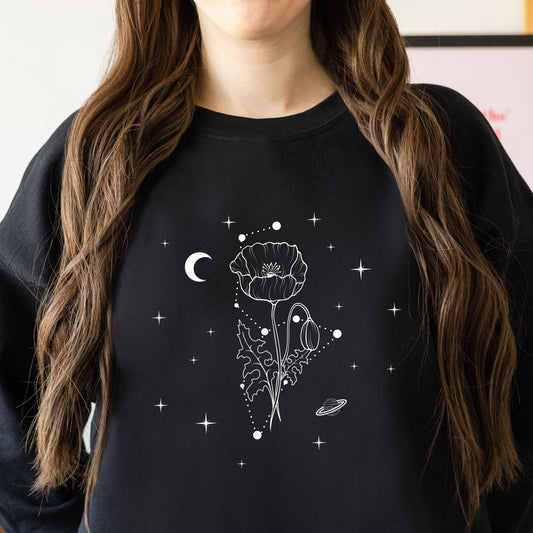 Person wearing a black sweatshirt with a white floral and celestial design.