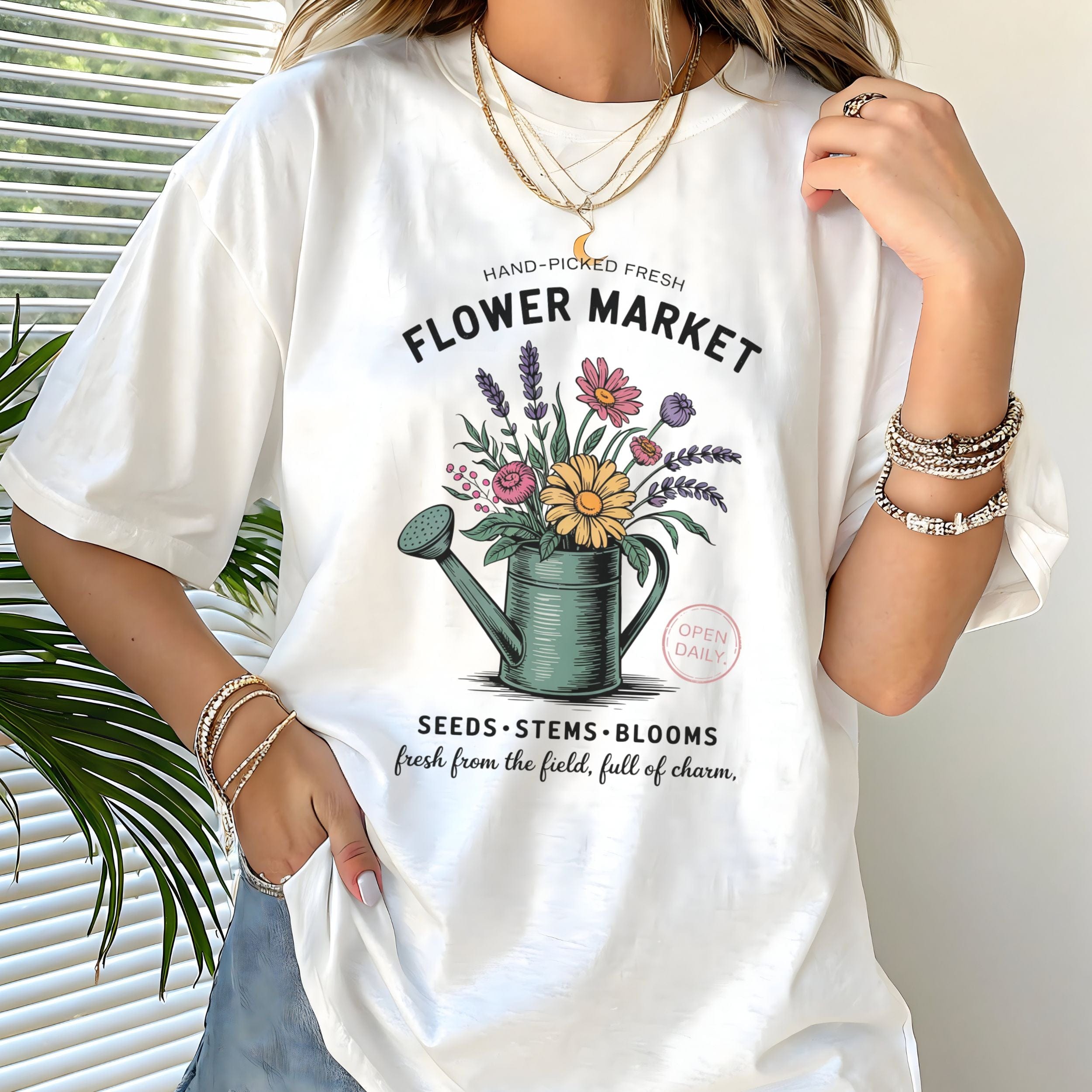 Person wearing a white t-shirt with a floral design and text.