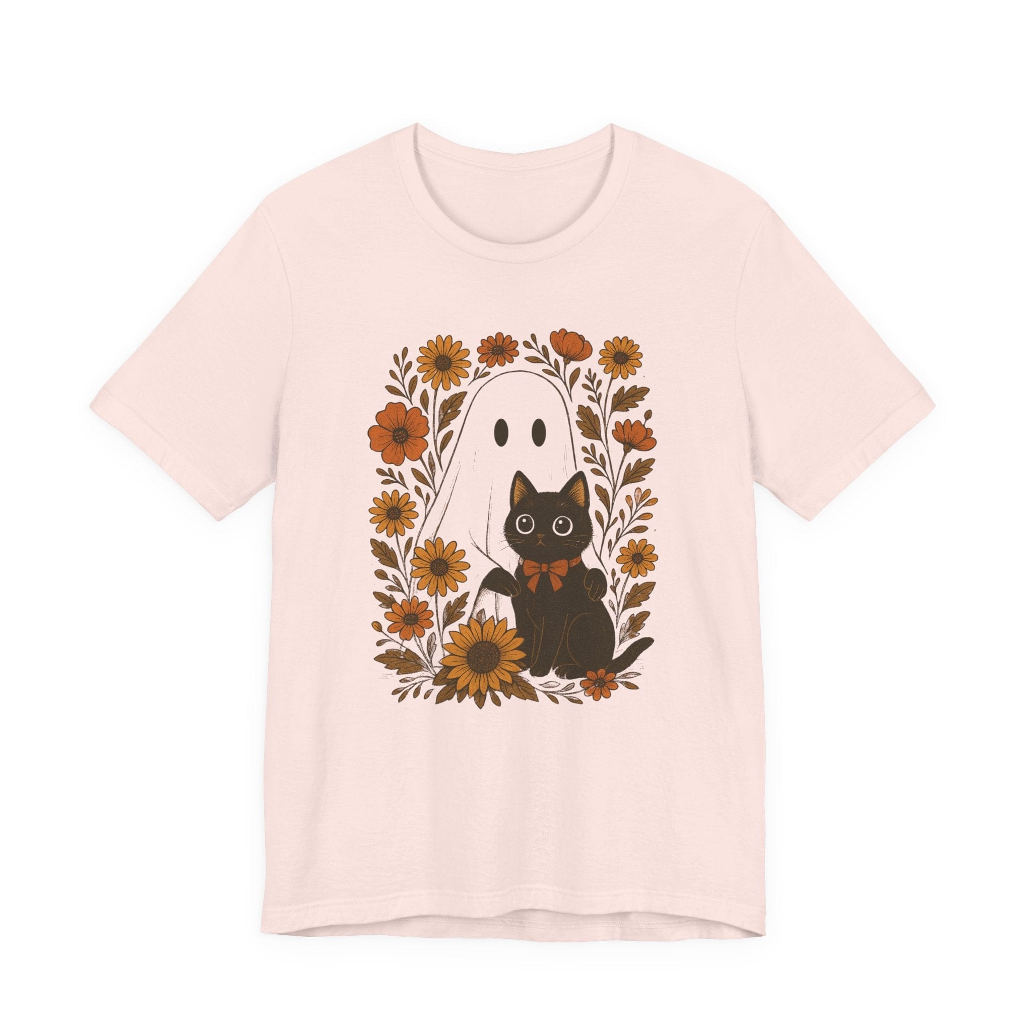 Flat lay of soft pink t-shirt with ghost and black cat surrounded by orange flowers