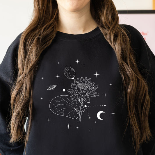 Person wearing a black sweatshirt with white floral and celestial design