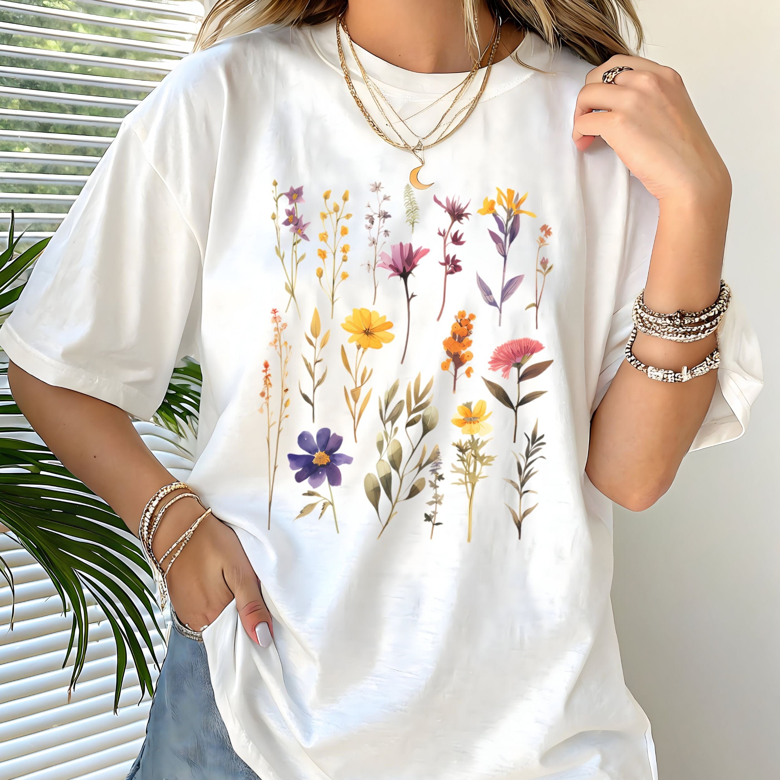 White t-shirt with floral design worn by a person, with a neutral background