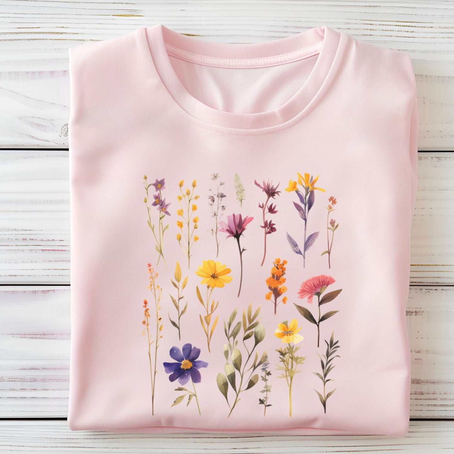Pink t-shirt with floral design on a wooden surface