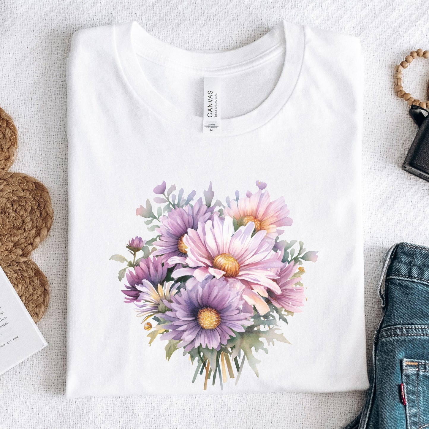 White t-shirt with a colorful floral design on a light gray surface.