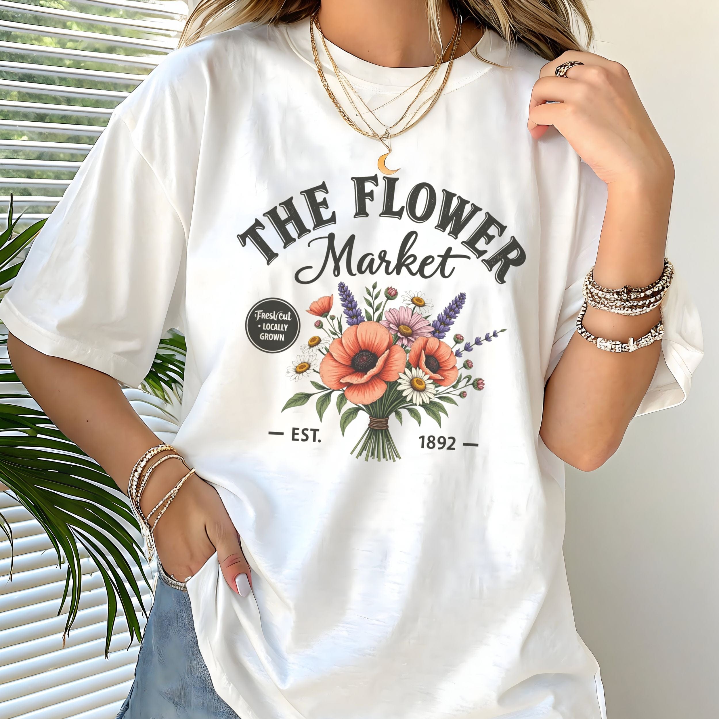 Person wearing a white t-shirt with 'The Flower Market' design.