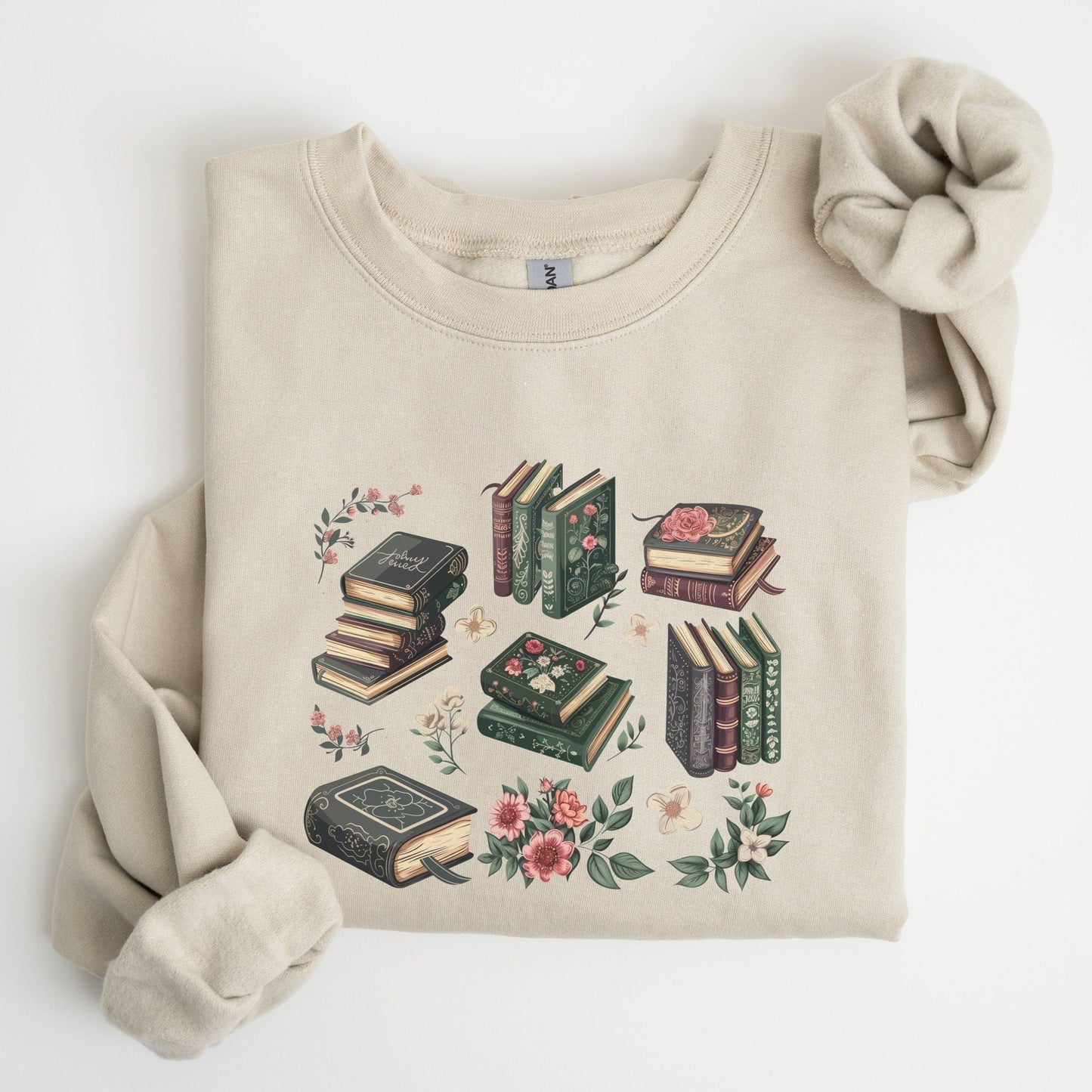 Beige sweatshirt with book and floral design on a white background