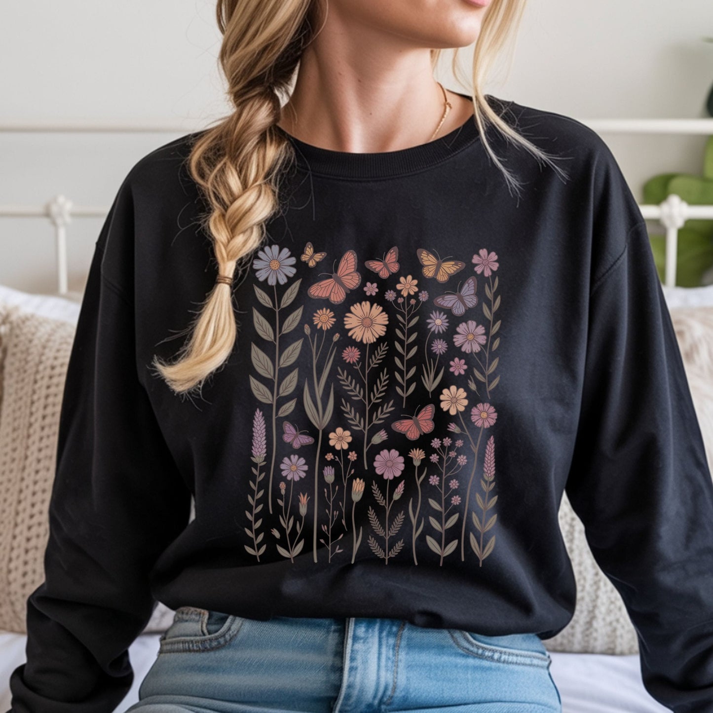 Person wearing a black long sleeve t-shirt with floral and butterfly design