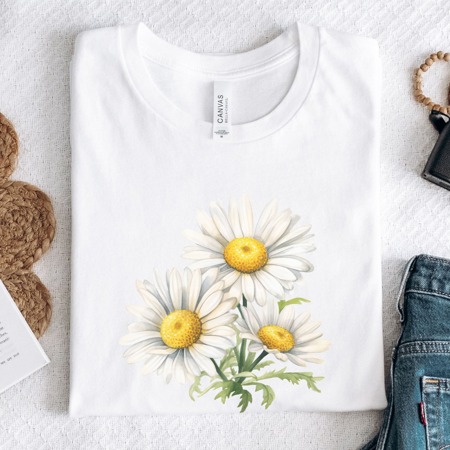 White t-shirt with daisy flower design on a light gray surface