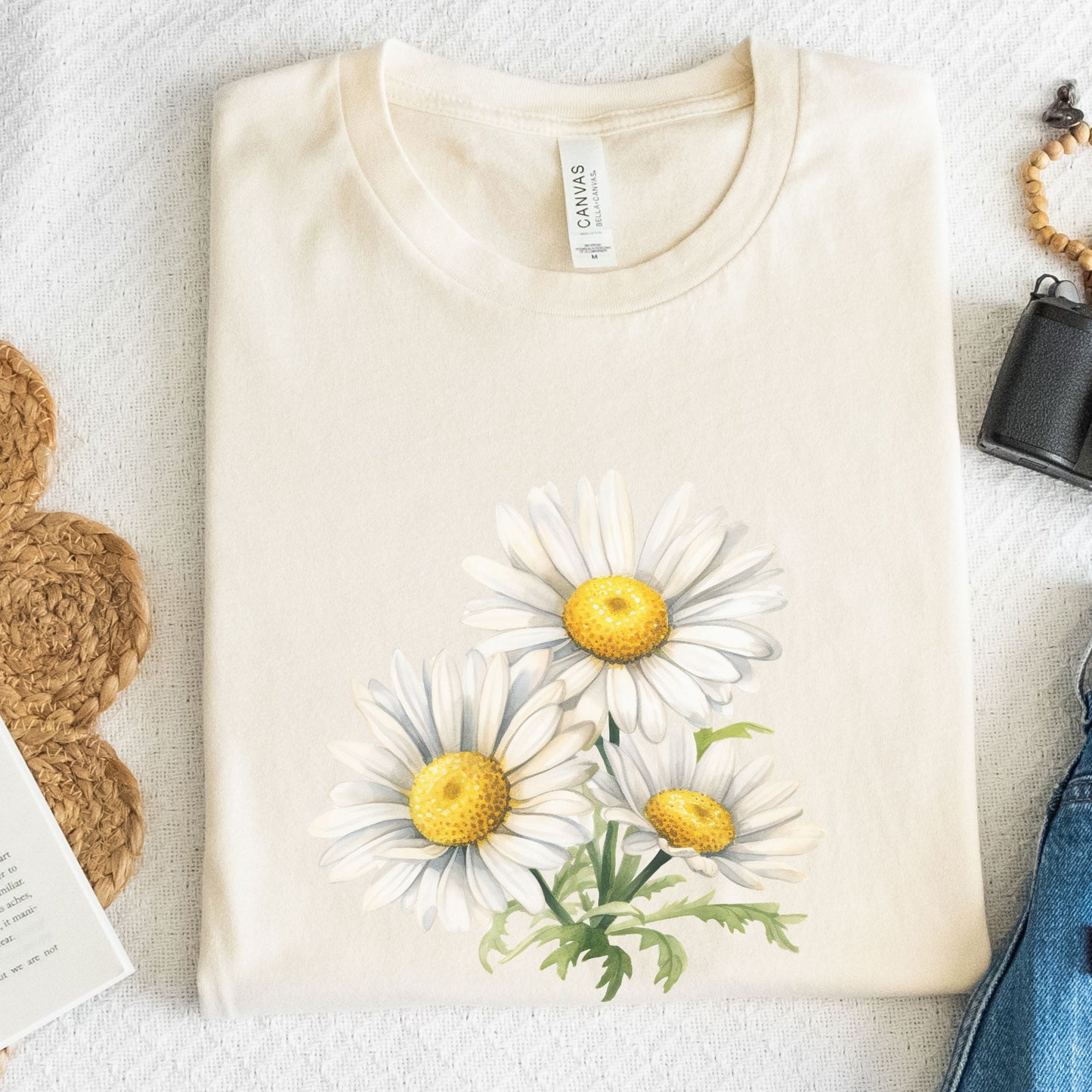 Beige t-shirt with daisy flower design on a textured surface