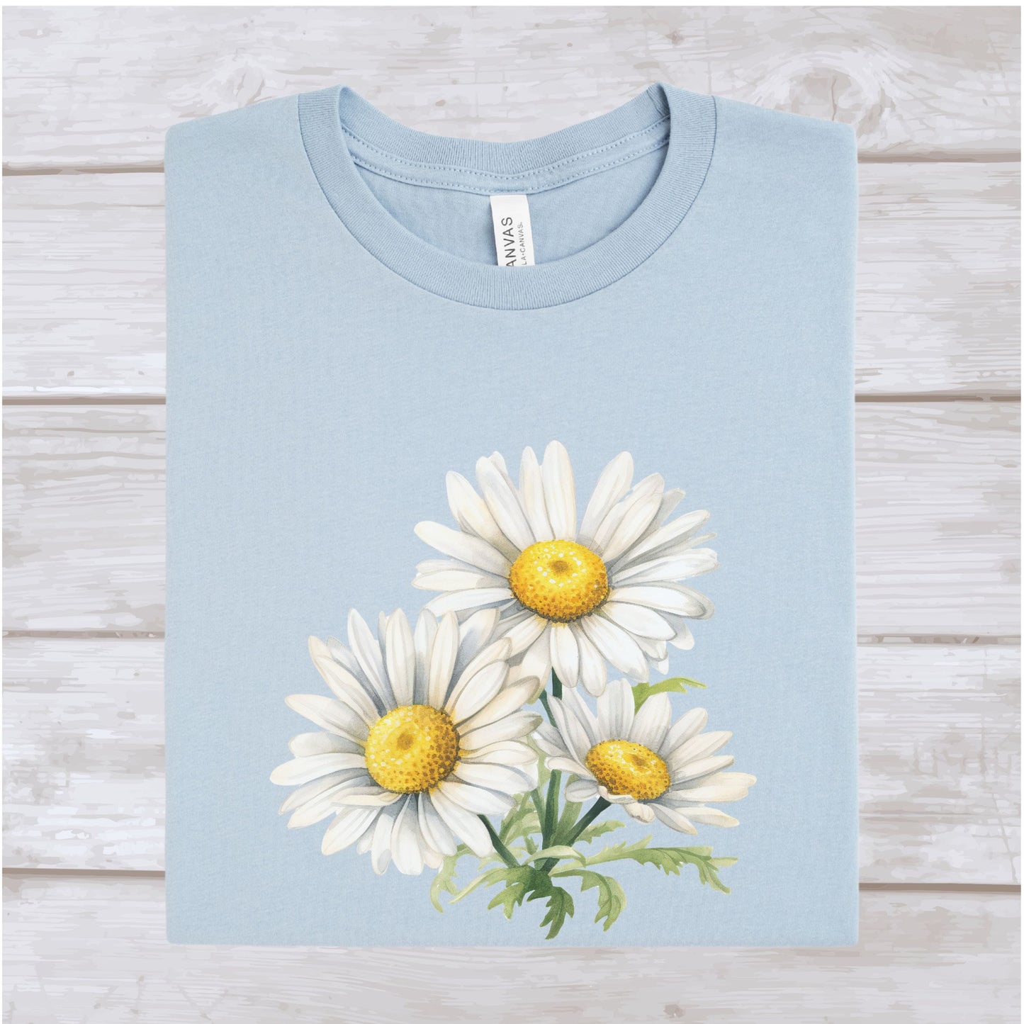 Light blue t-shirt with white daisy design on a wooden surface