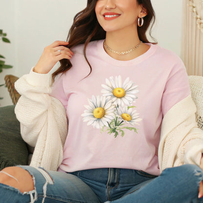 Person wearing a pink t-shirt with floral designs sitting on a couch.