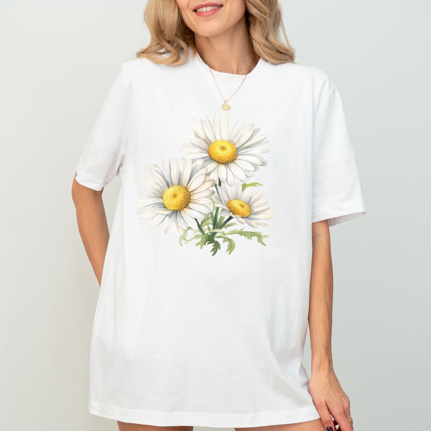 White t-shirt with daisy flower design worn by a model on a plain background