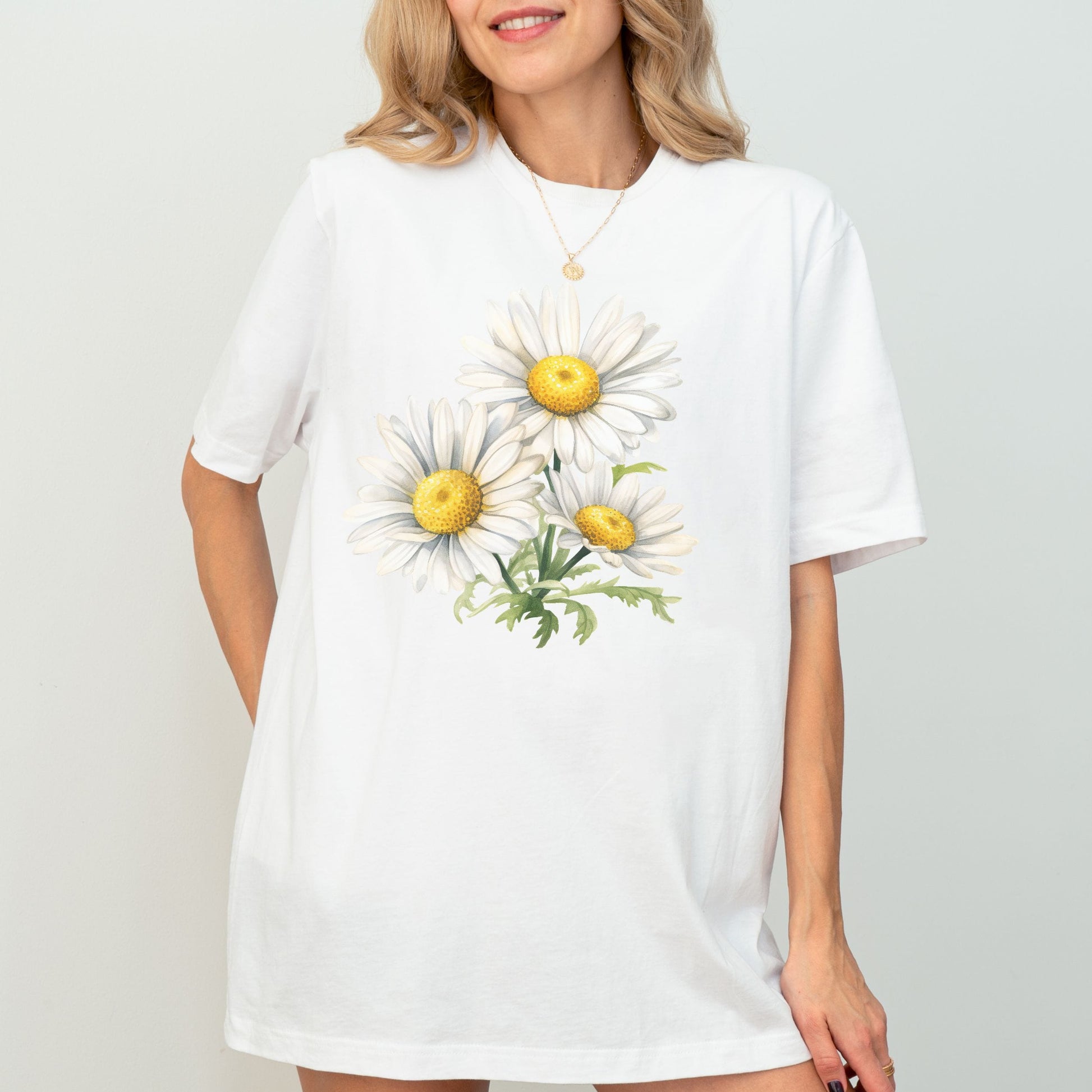 White t-shirt with daisy flower design worn by a model on a plain background