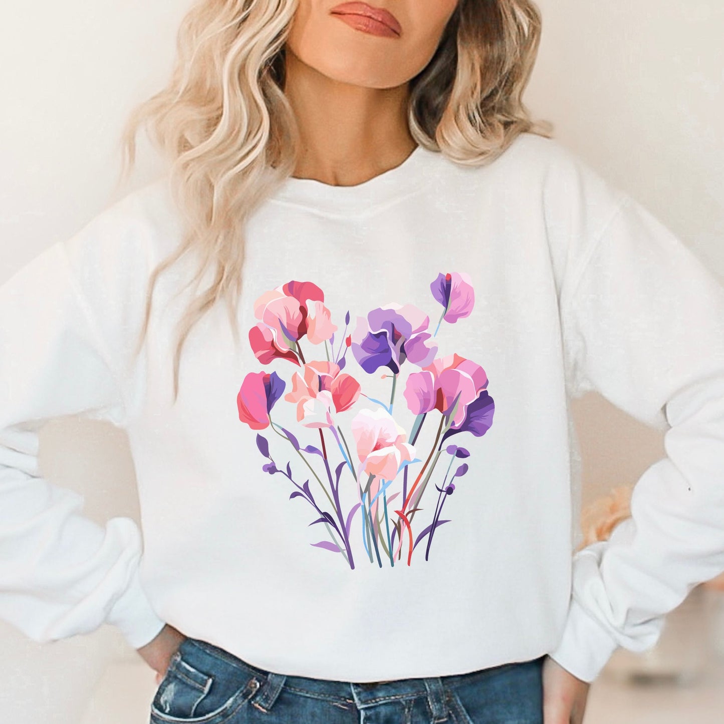 White sweatshirt with a colorful floral design worn by a person.
