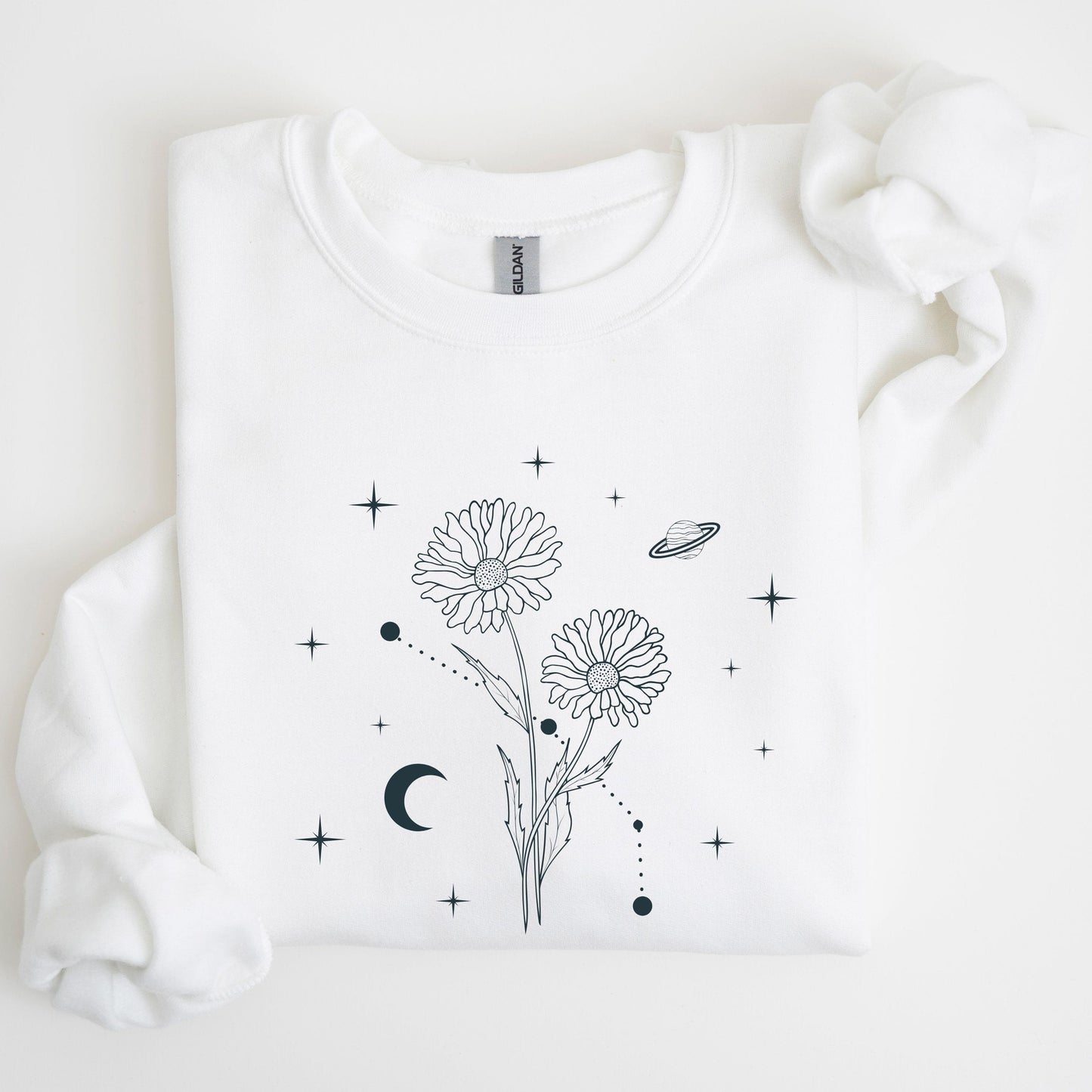 White sweatshirt with black floral and celestial design on a light background
