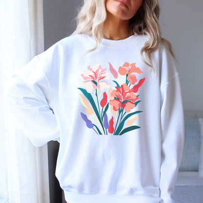 White sweatshirt with colorful floral design worn by a person indoors.