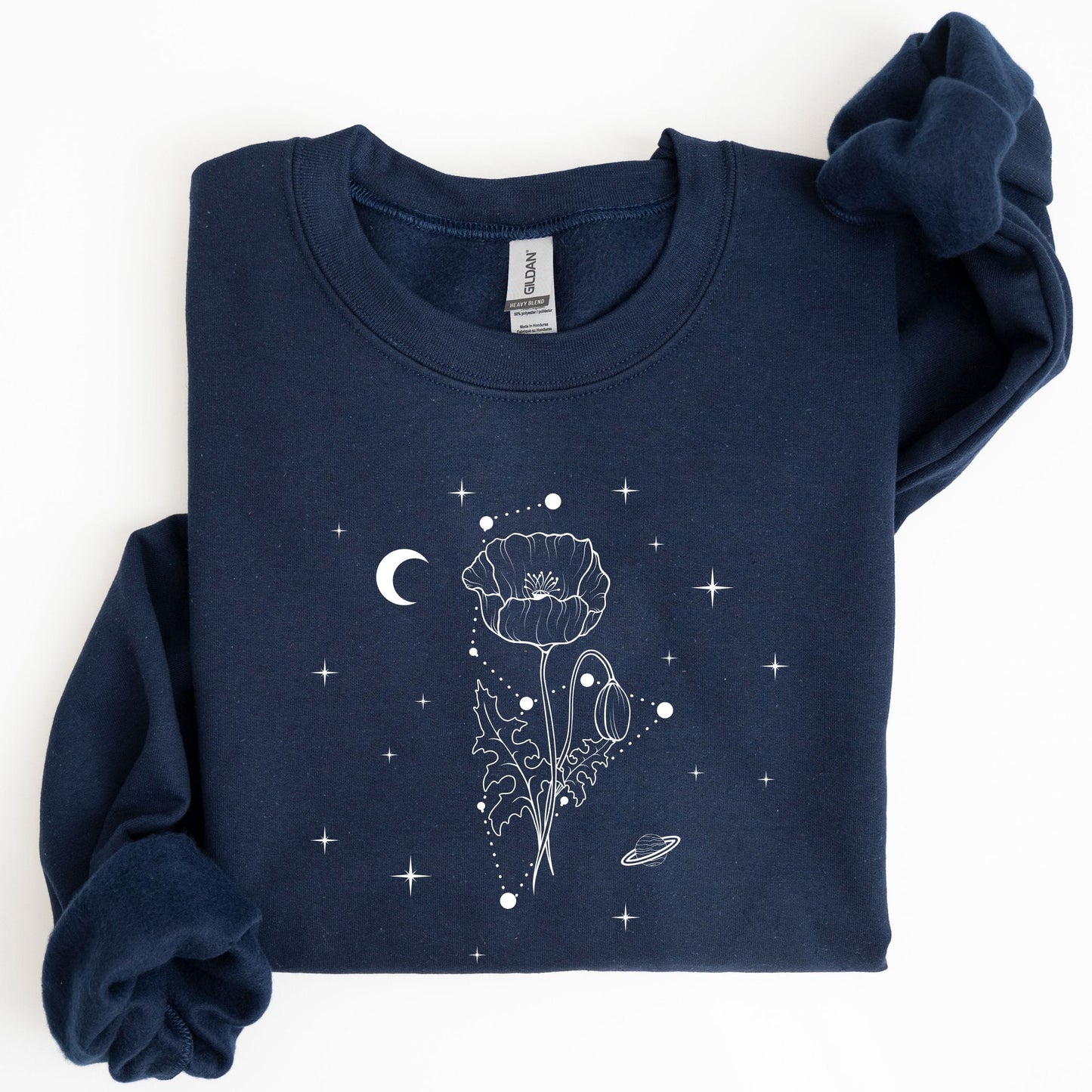 Folded navy blue sweatshirt with celestial design on a white background