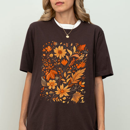 Person wearing a brown t-shirt with orange floral design on a plain background