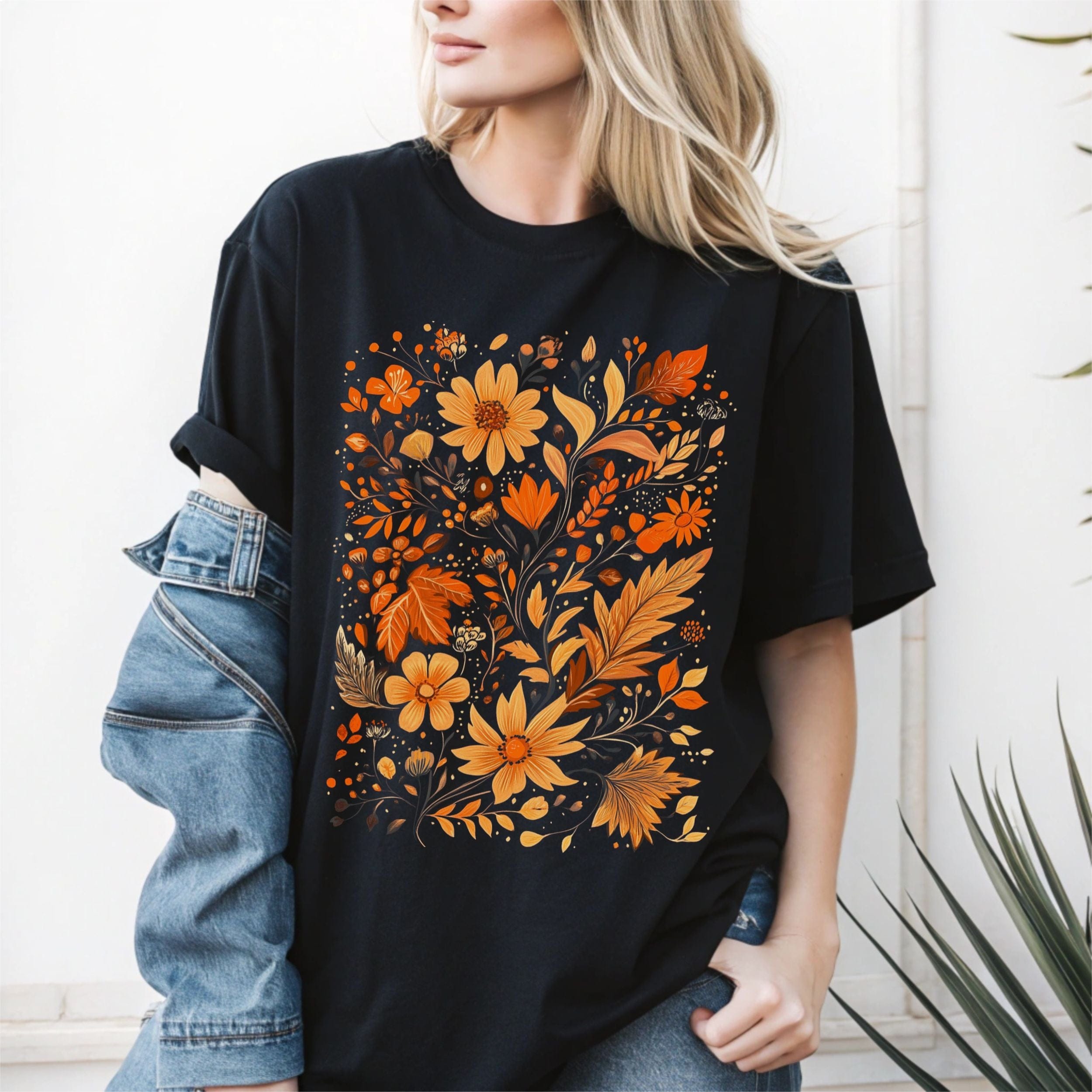 Person wearing a black t-shirt with orange floral design