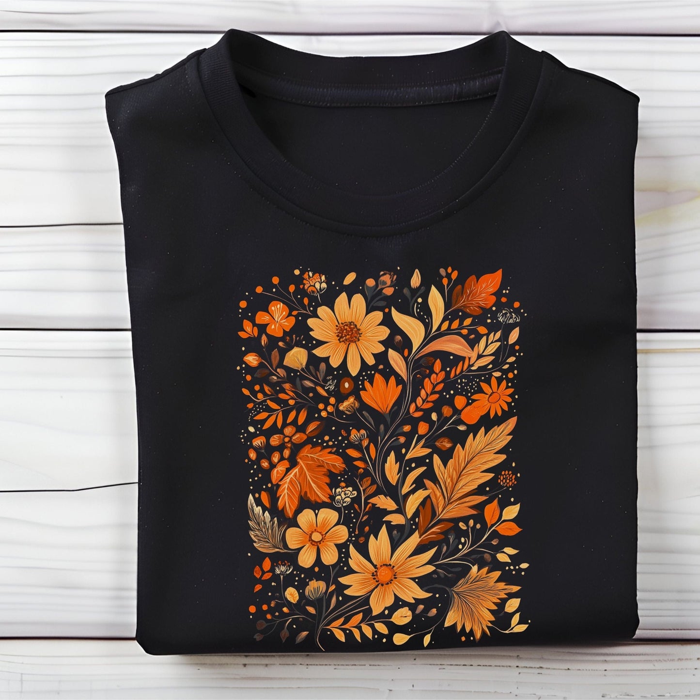 Flat lay of black t-shirt featuring orange and gold autumn floral design