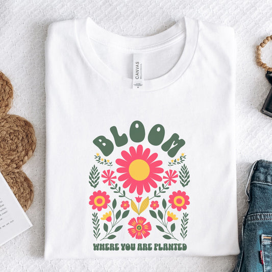 White t-shirt with floral design and text on a textured surface