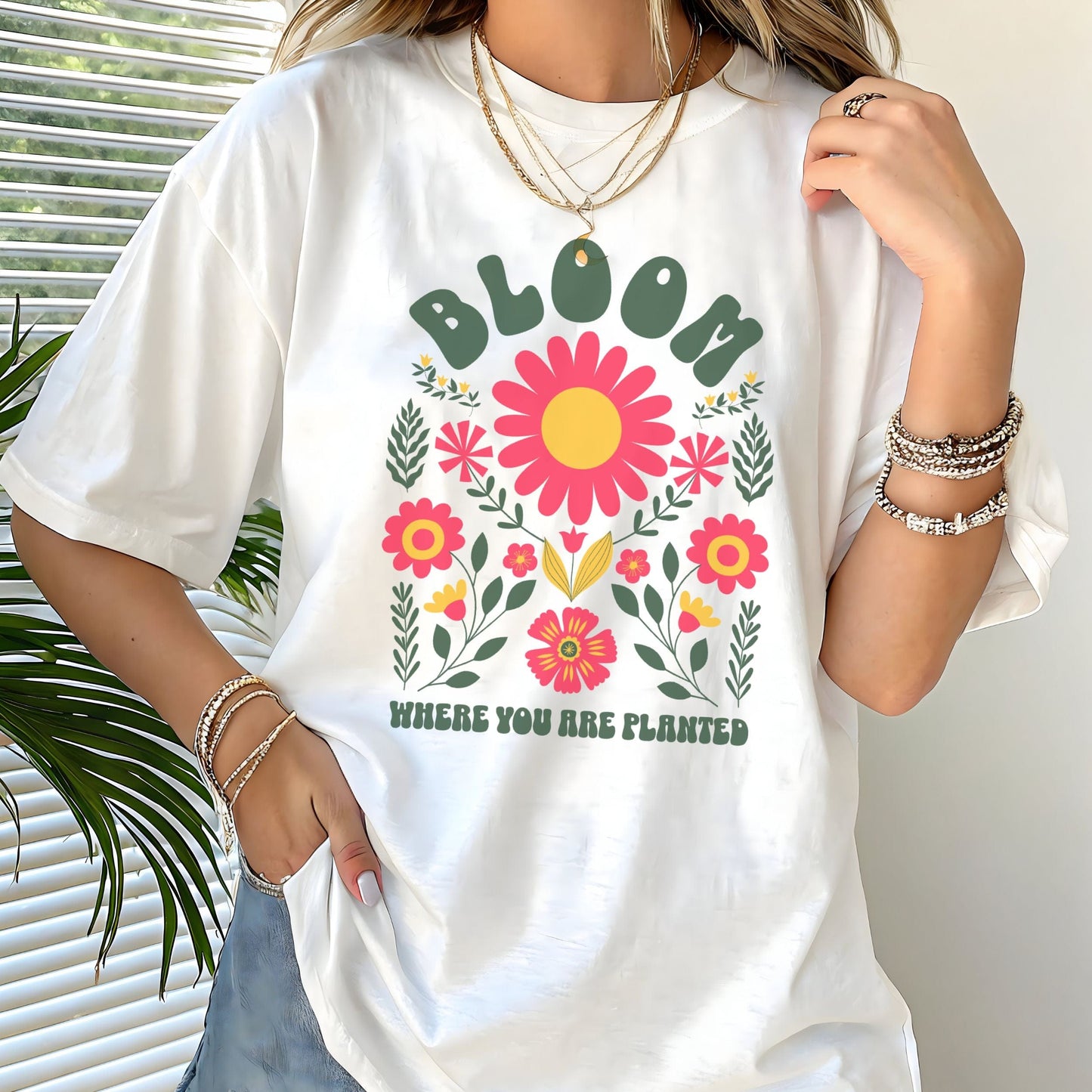 Person wearing a white t-shirt with floral design and text
