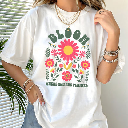 Person wearing a white t-shirt with floral design and text