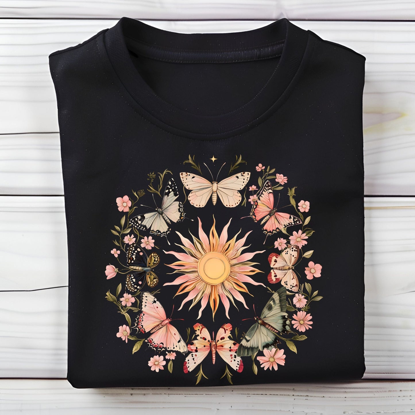 Black long sleeve t-shirt with butterfly and floral design on a wooden surface