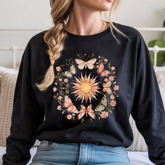 Person wearing a black long sleeve t-shirt with a colorful sun and butterfly design.