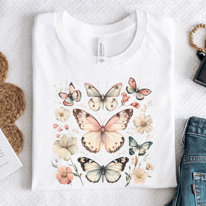 White t-shirt with butterfly and floral design on a textured surface.