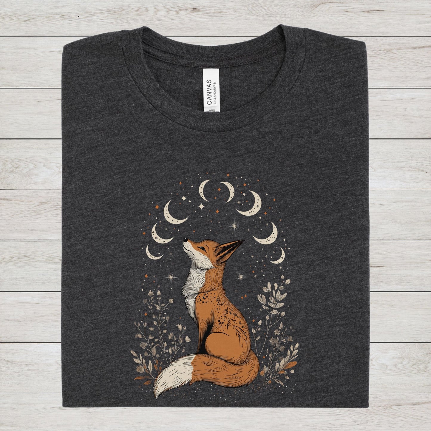 Dark heather gray t-shirt with a fox and moon design on a wooden surface