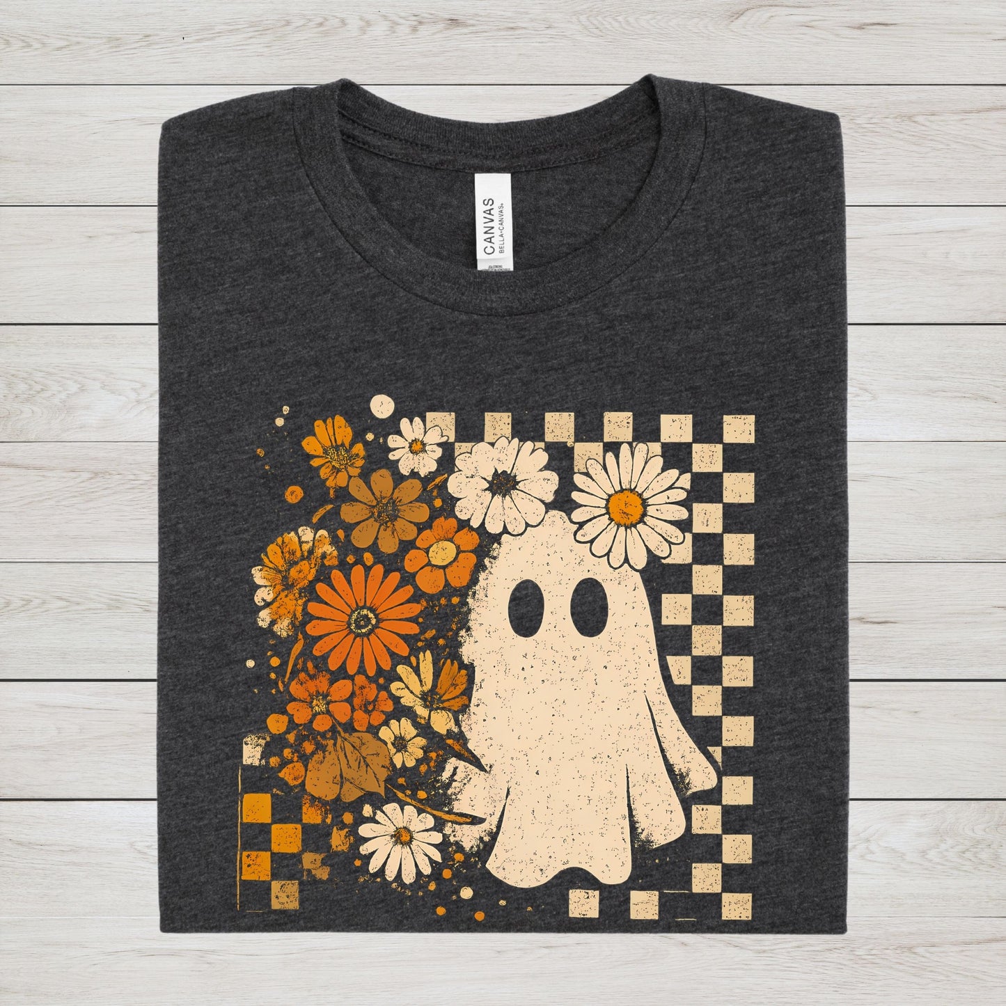 Dark gray t-shirt with a ghost and floral design on a wooden surface