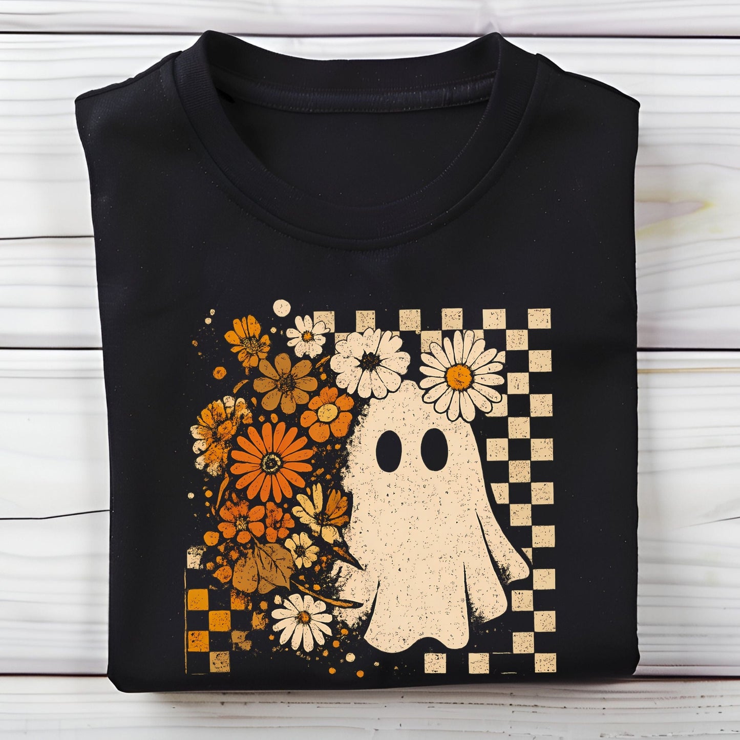 Black t-shirt with a ghost and floral design on a wooden surface