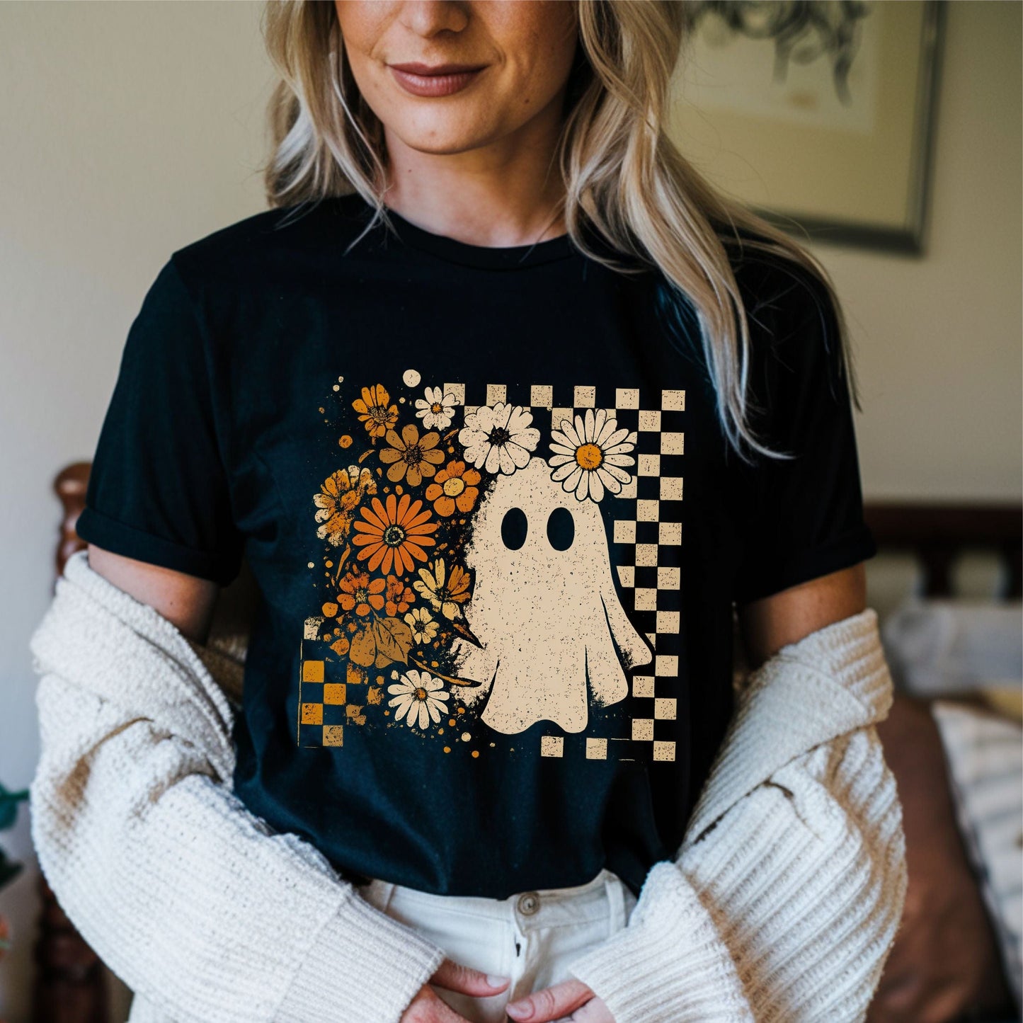 Person wearing a black t-shirt with a ghost and floral design.