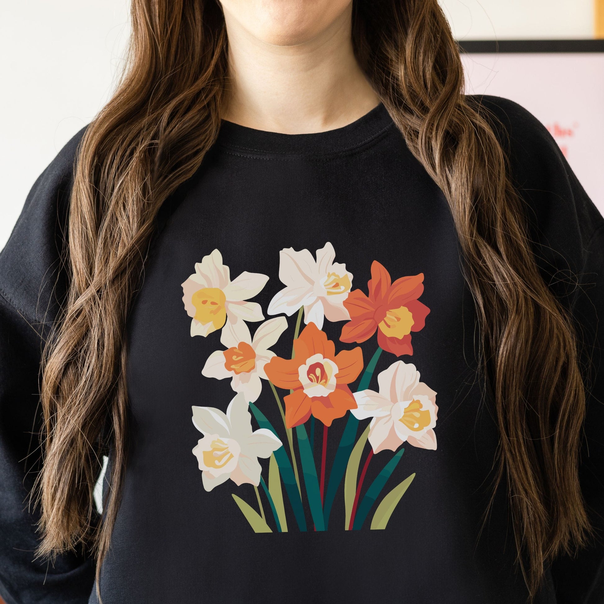 Person wearing a black sweatshirt with a colorful floral design.