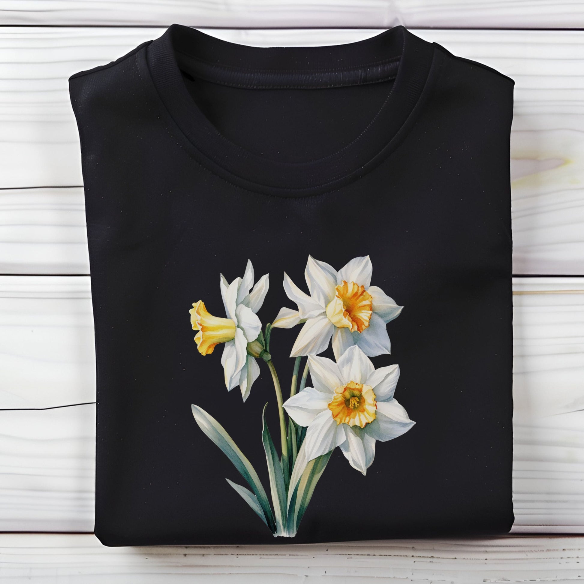 Black t-shirt with white daffodil flowers on a wooden surface