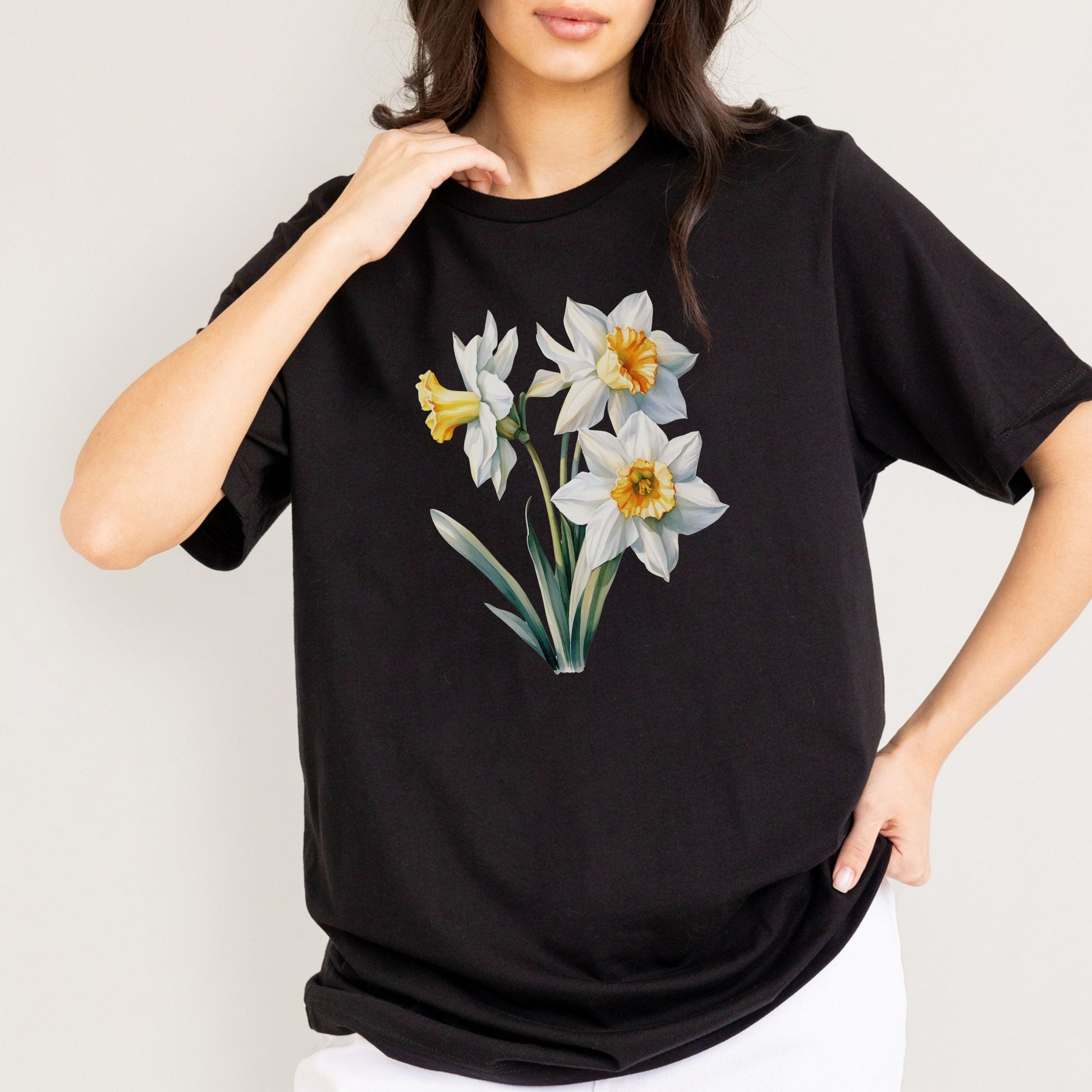Person wearing a black t-shirt with floral design on a plain background