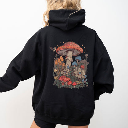 Person wearing a black hoodie with a colorful mushroom design on the back against a white background