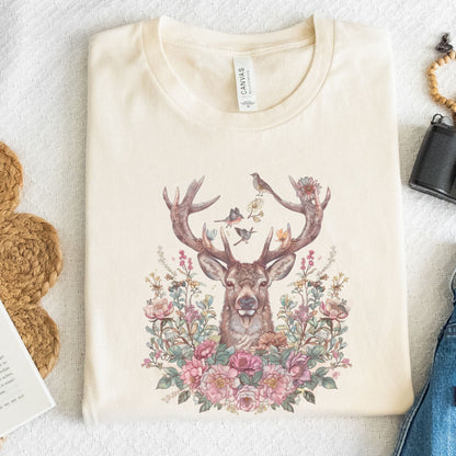 Beige t-shirt with a deer and floral design on a textured surface.