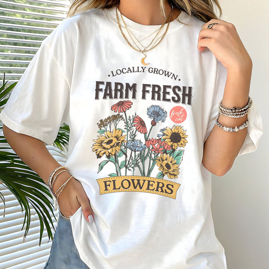 Person wearing a white t-shirt with 'Farm Fresh Flowers' graphic design.