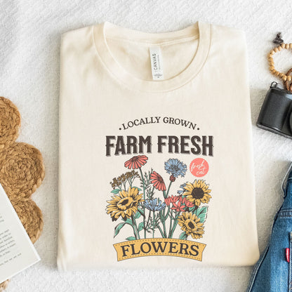 Beige t-shirt with 'Farm Fresh Flowers' graphic on a white surface