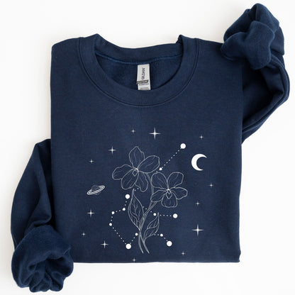 Folded navy blue sweatshirt with white floral and celestial design on a white background