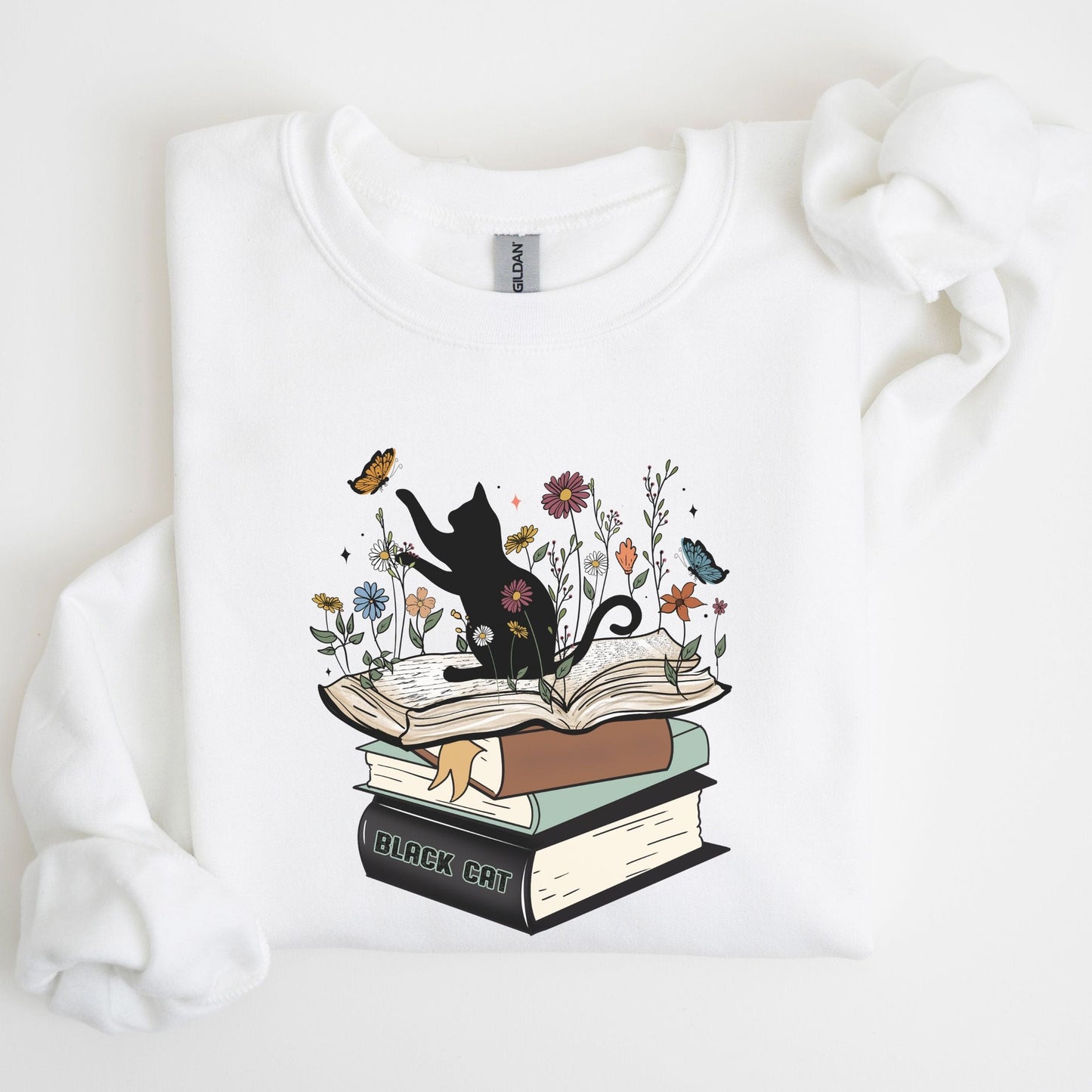 White sweatshirt with a black cat and book design on a white background