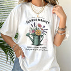 Person wearing a white t-shirt with a floral design and text.