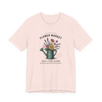 Pink t-shirt with floral design and text on a white background