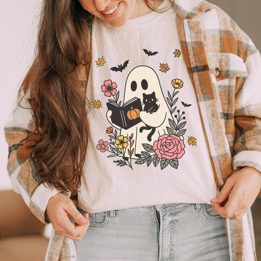 Person wearing a white t-shirt with a ghost design, plaid jacket, and jeans.