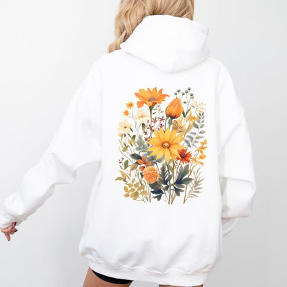 A person shown from the back wearing a white pullover hoodie with a large colorful floral print on the back, photographed against a clean white studio background.