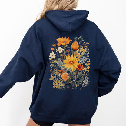 A person wearing a navy blue hoodie from the back, featuring a large colorful floral print with yellow, orange, and white flowers on the back.