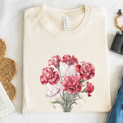 Folded cream-colored t-shirt with a floral design on a textured surface.