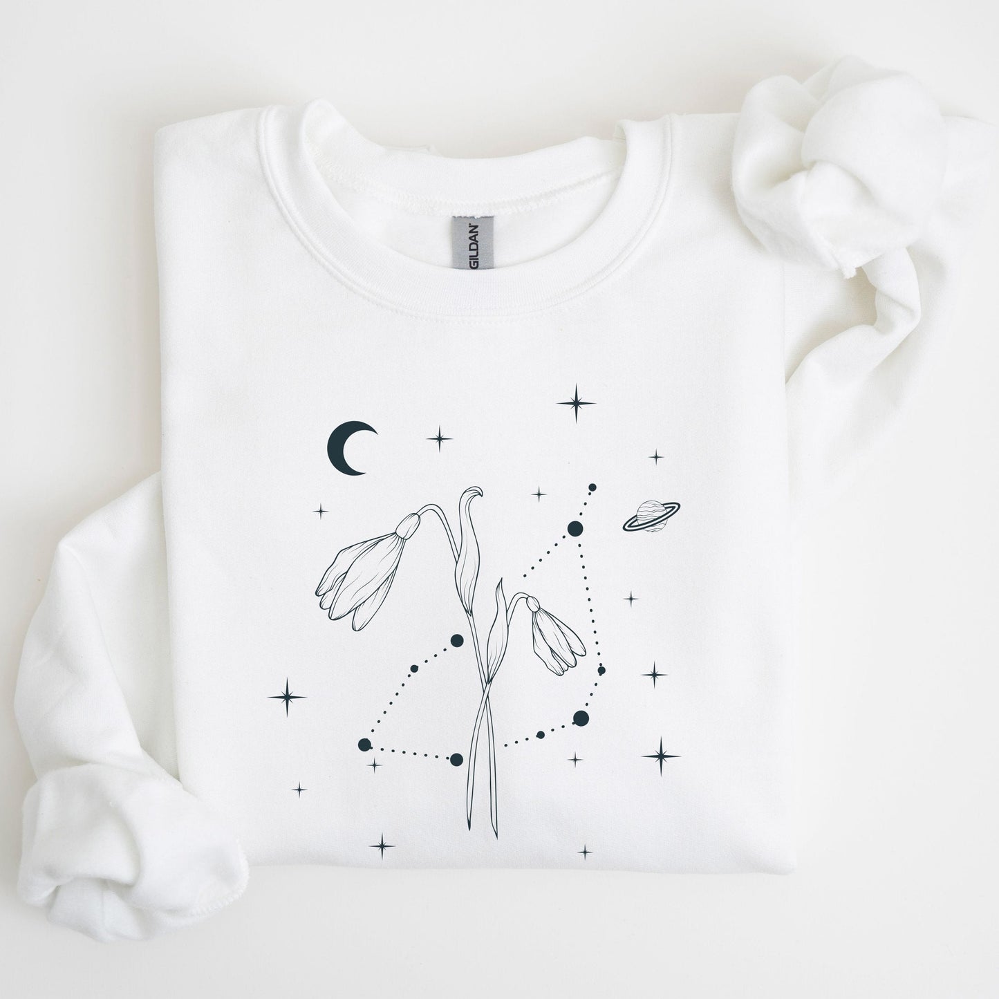 White sweatshirt with black floral and celestial design on a light background