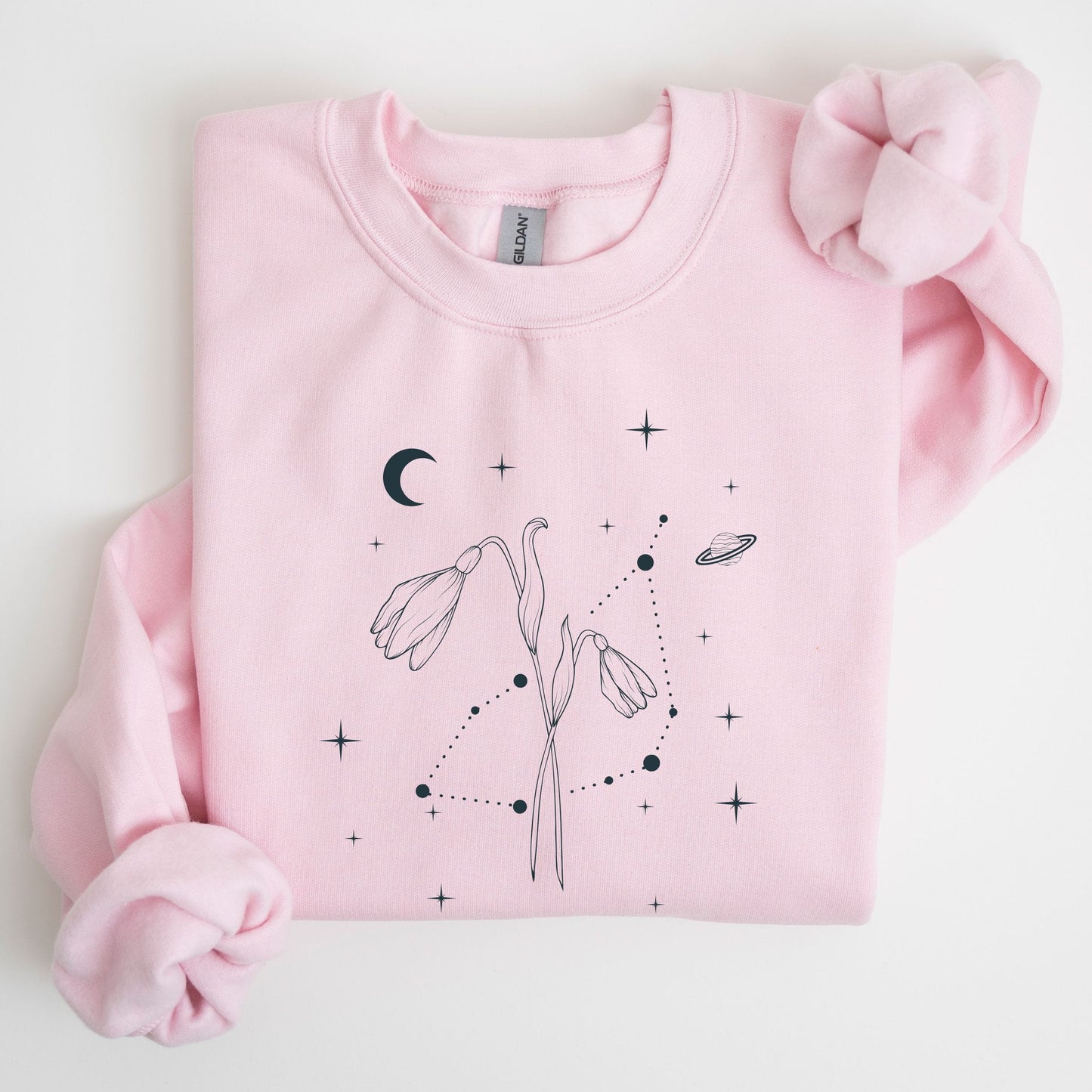 Pink sweatshirt with celestial design on a light gray background